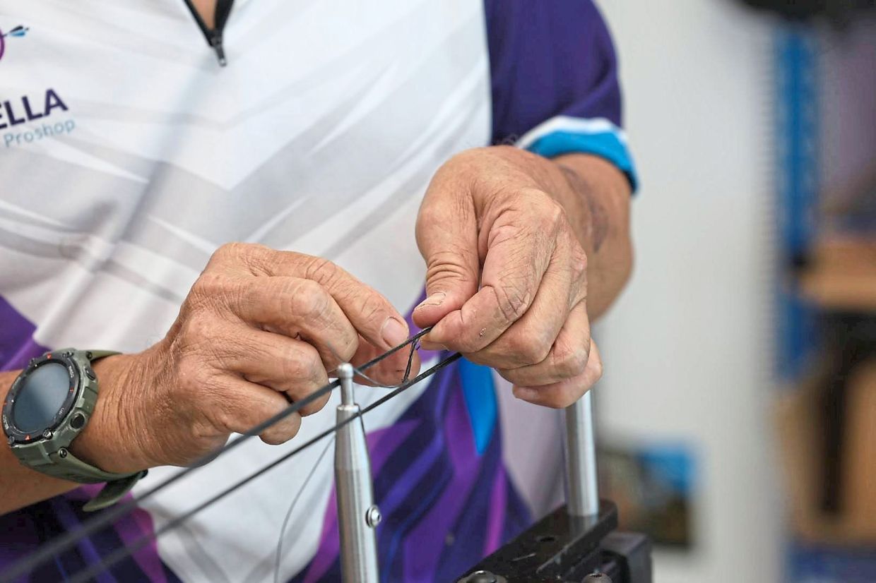 Fingers weave tension and trust into every knot of a handmade bowstring.