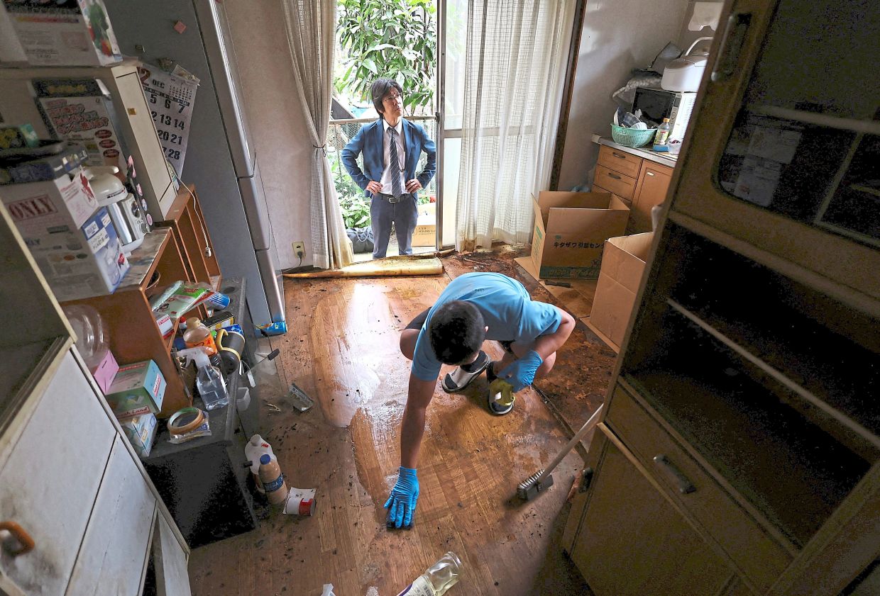 Deep clean: Ookuma looking on while a worker cleans a floor at a ‘jiko bukken’ or ‘misfortunate property’ in Ichikawa, near Tokyo. — Reuters