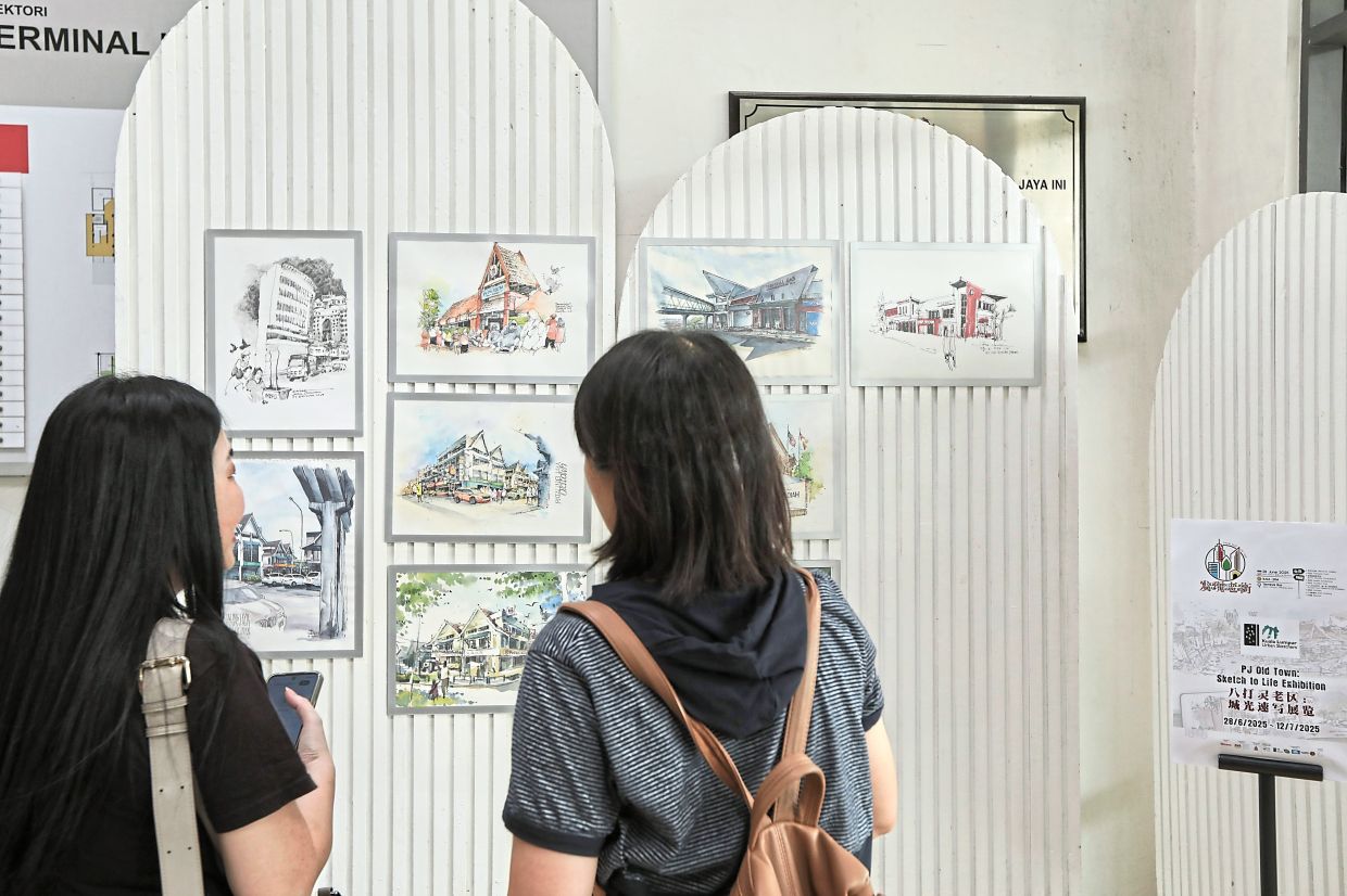 Visitors viewing artworks which will be on display at Jalan Othman Bus Terminal in Petaling Jaya Old Town until July 12. — Photos: YAP CHEE HONG/The Star