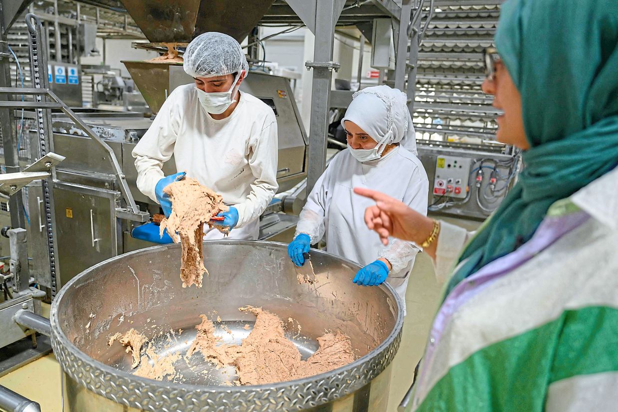 Halk Ekmek employees mixing and cutting dough to make Kulluoba bread. — AFP