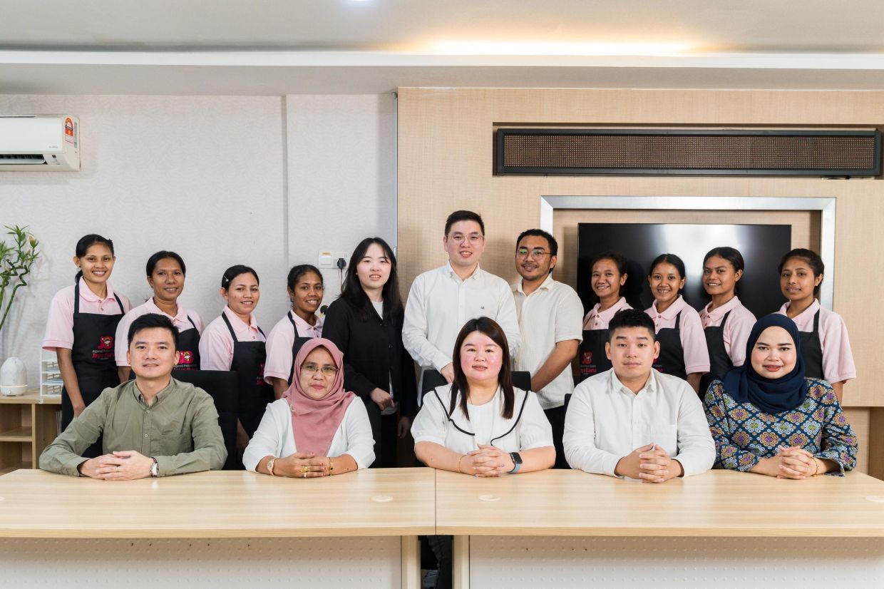 Ng (standing, centre) and his team at Agensi Pekerjaan Jaya Baru. The company is focused on matching families with the most suitable helpers by improving recruitment standards and offering professional training.