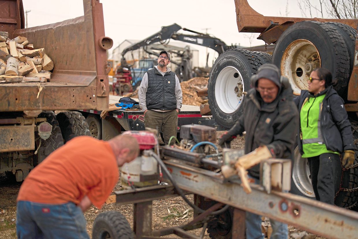 Kalke, general manager of Sustainable Energy for Galena, Alaska, watches as some of his workers split logs.