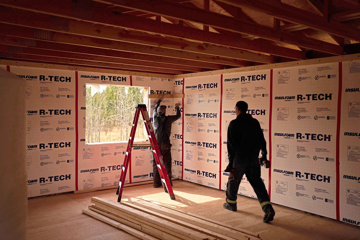 Joe Cleaver II (left) and Derrick Esmailka build an energy-efficient home.