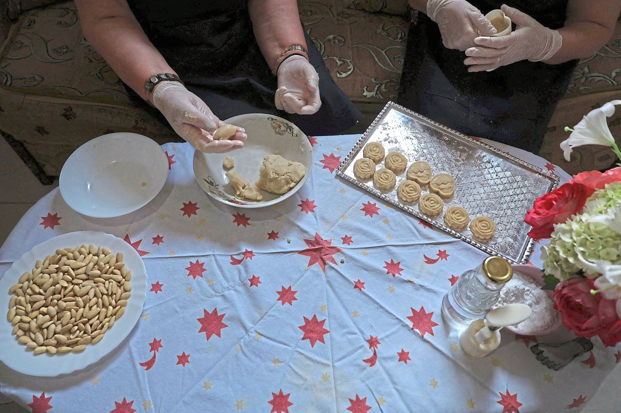 Women preparing traditional Albanian sweets with rose water in their workshop.