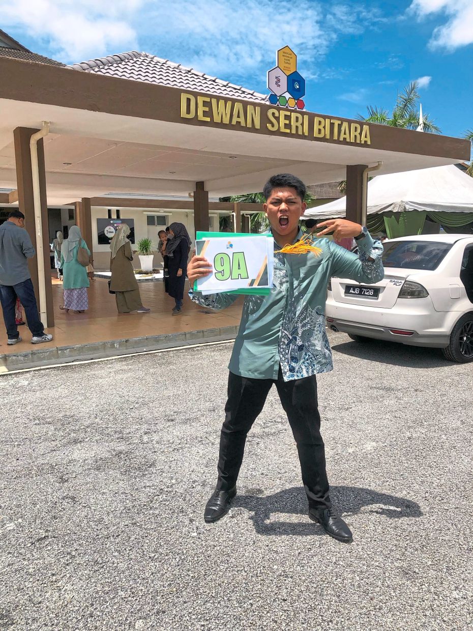 Youngest brother Luth Mikhail Rafie celebrating joyfully after achieving straight As in his SPM results.
