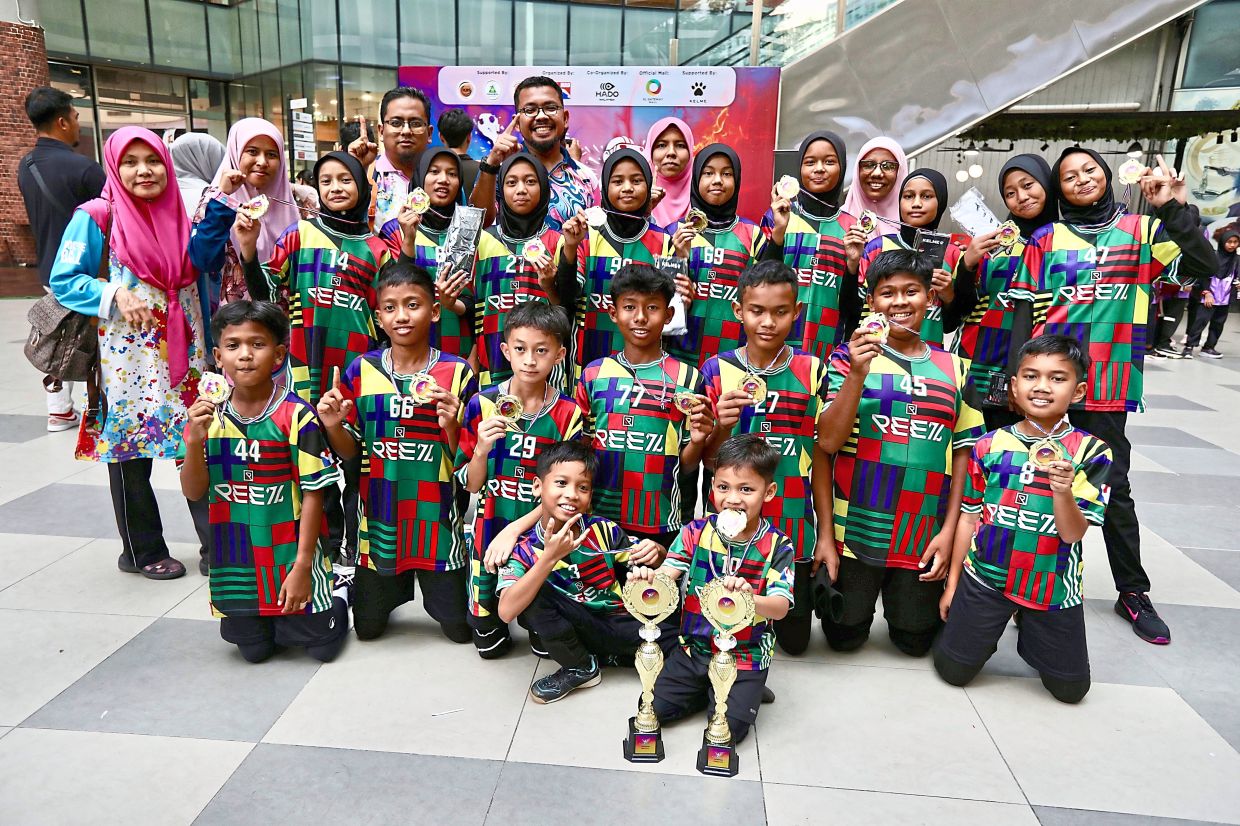 Mohamad Shahdan (back row, fourth from left) and other teachers with the winning Team Hippos U12 Girls’ and Boys’.
