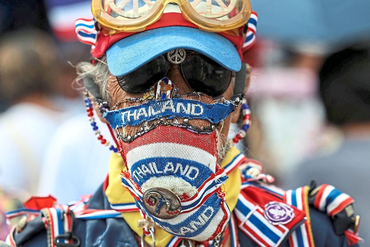 A protester wearing a face mask with the colours of the Thai flag during an anti-government demonstration in Bangkok. — AP/Bloomberg