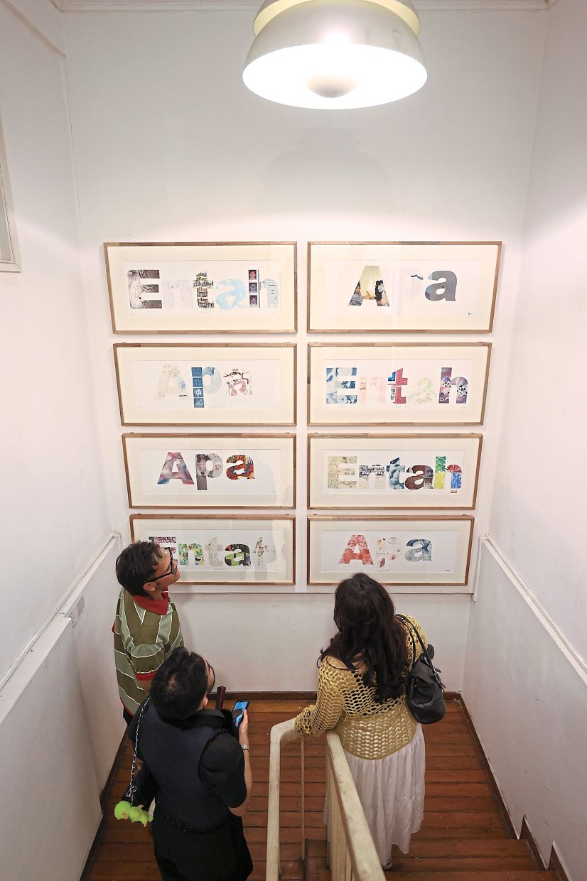 Visitors pause at the staircase to view Binti’s 'Entah Apa' series at Cult Gallery. Photo: The Star/Glenn Guan 
