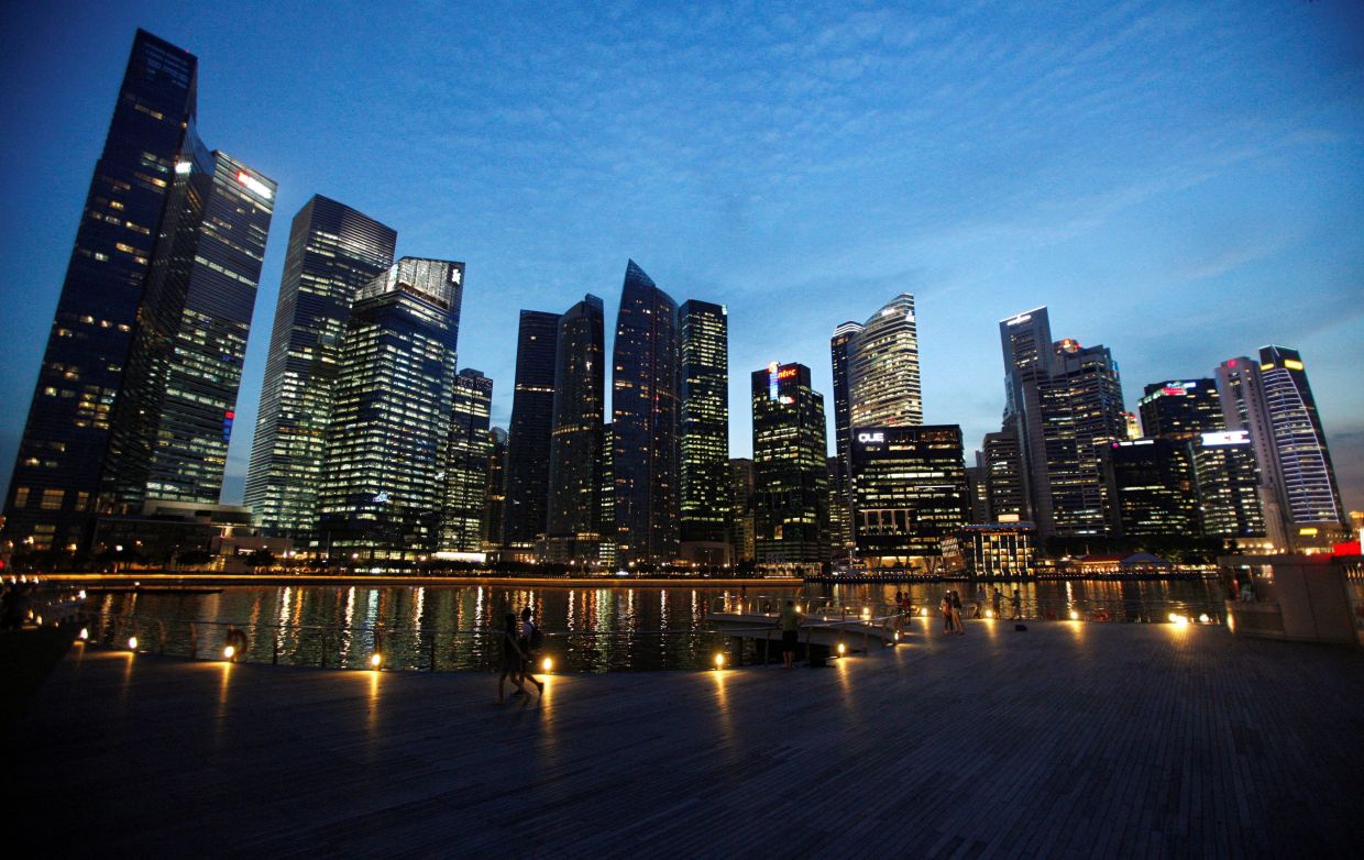 People walk past the skyline of Marina Bay central business district in Singapore April 26, 2013. -- Reuters