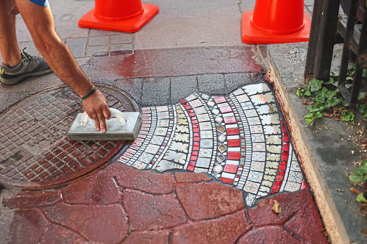 Ememem's artworks - made of recycled materials, bits of glass and broken or discarded shards of pottery - are what he calls his 'plasters for the pavement'. Photo: AFP 