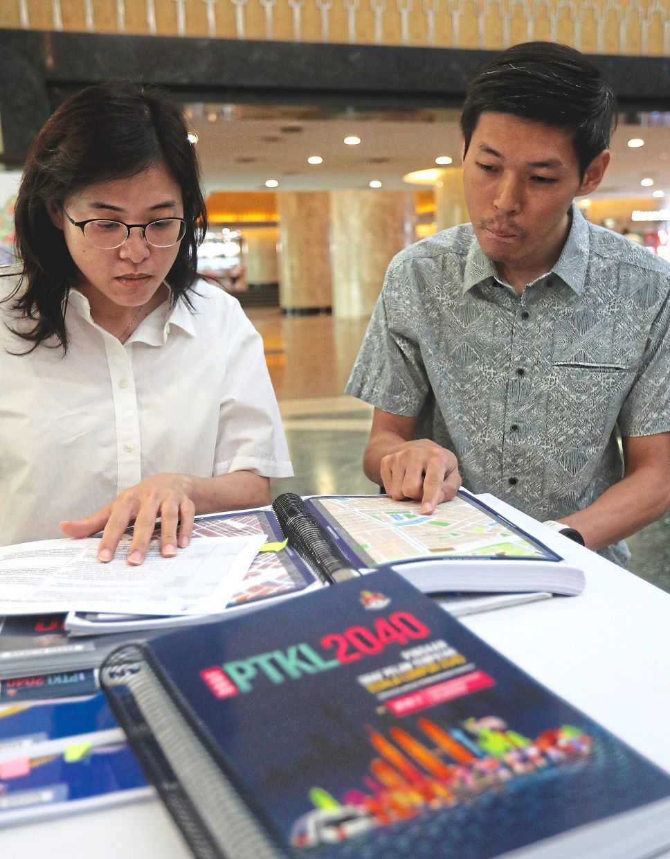 Evelyne (left) and Joshua looking at the number of STPs rezoned for commercial projects in KLLP2040.
