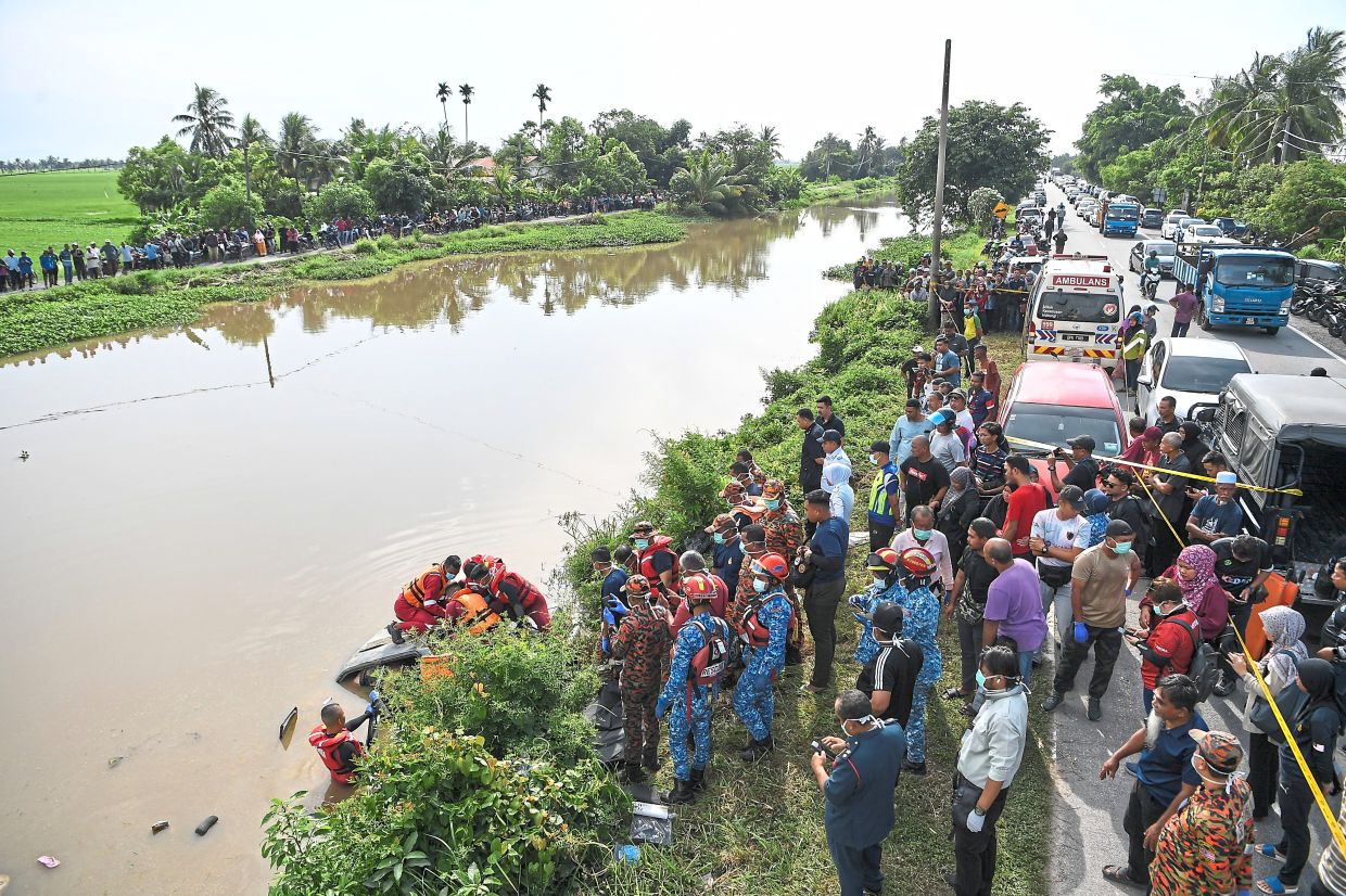 Tragic end: The bodies of a family of six were found in a car (seen below) in Sungai Korok, near Jitra. — Bernama