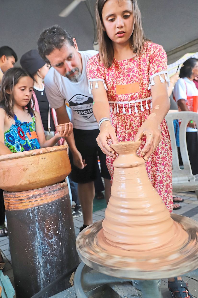Tourists trying their hand at making pottery during an activity at the 17th edition of George Town Heritage Celebrations. 