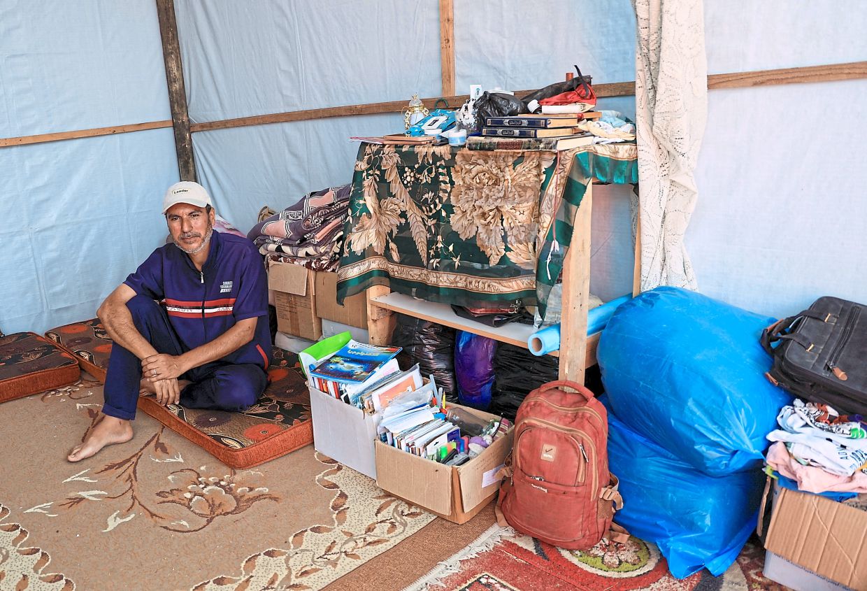 Nizam sitting inside the tent where he and his family have taken refuge, in Khan Yunis, southern Gaza Strip. — Reuters