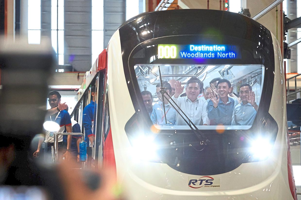 Loke (third from right), Siow (second from right) and Johor Mentri Besar Datuk Onn Hafiz Ghazi (right) on the new RTS Link train unveiled at the Singapore Rail Test Centre (SRTC).