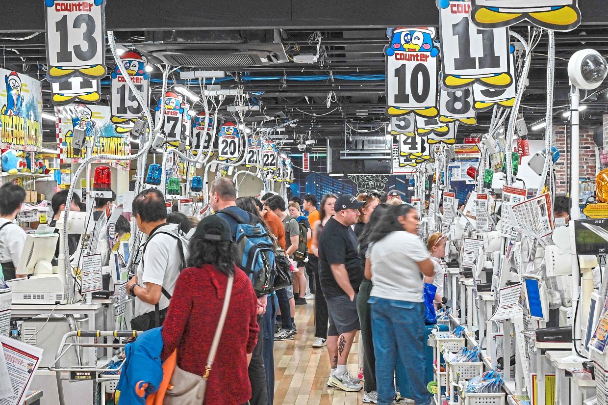 Deals galore: Tourists lining up at the tax free checkout tills at the Don Quijote in Shibuya. — AFP 