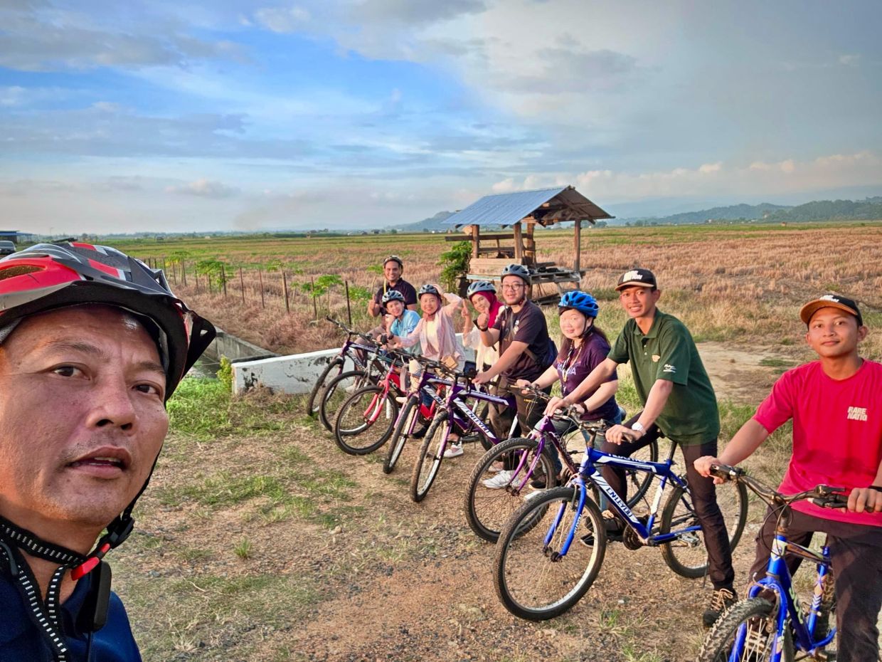 A Tourism Malaysia official taking a group photo before cycling.