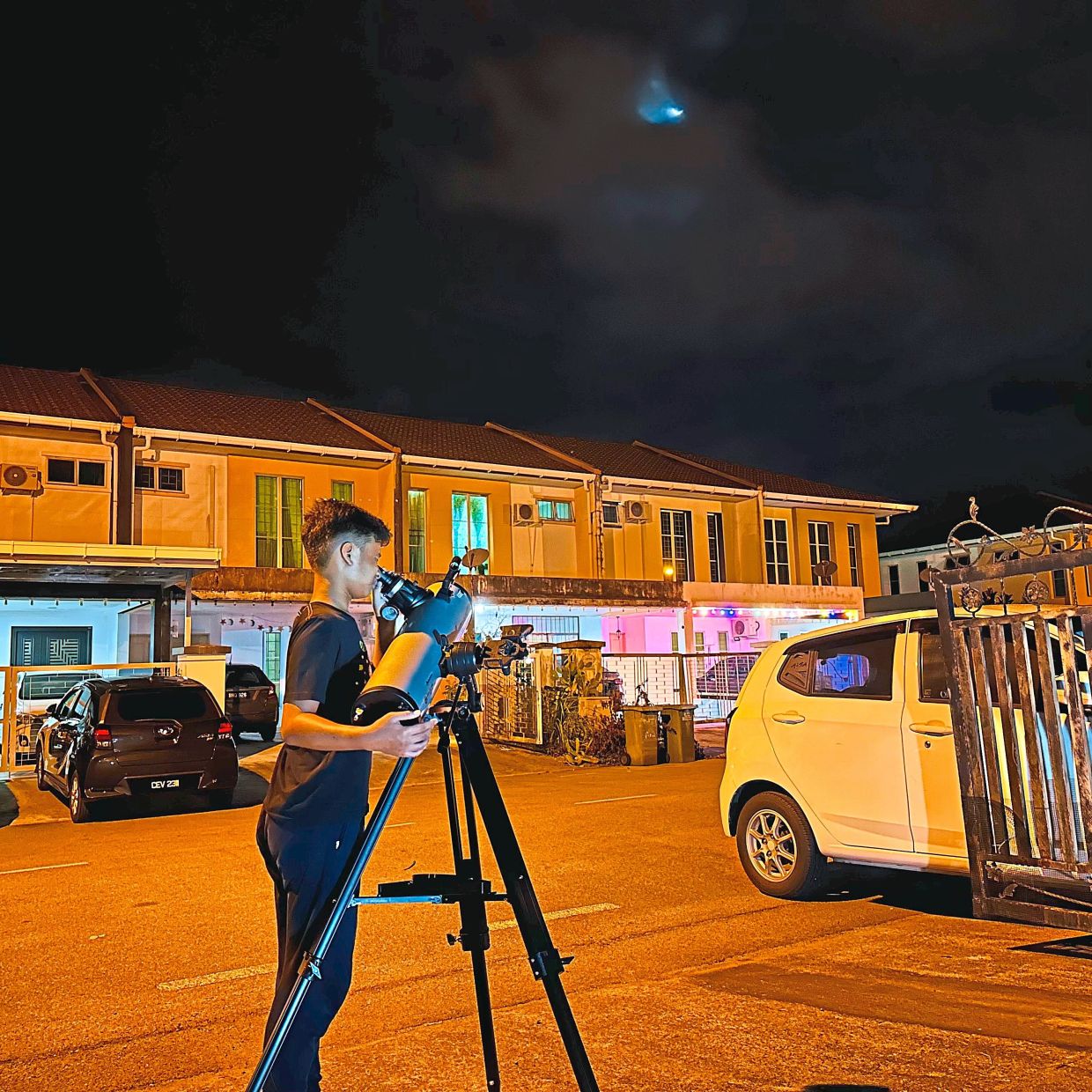 Muhammad Umar looking at the moon through his mother’s telescope from his house in Kuching, Sarawak.