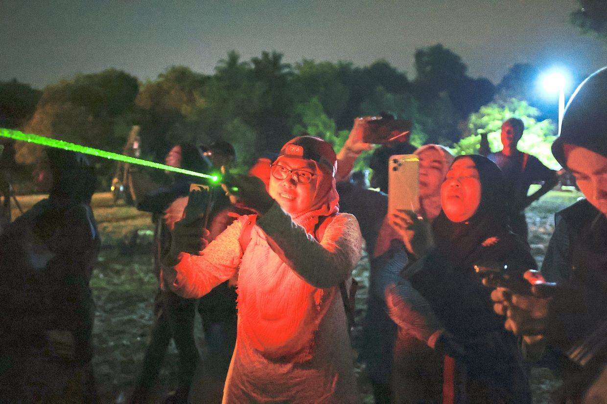 Nurul Fatini (holding green laser pointer) suggests that parents and teachers take young ones to observatories and science centres to nurture their curiosity.