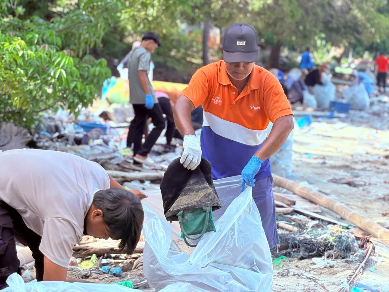 Volunteers clean up plastic and debris along Selakan’s shoreline.