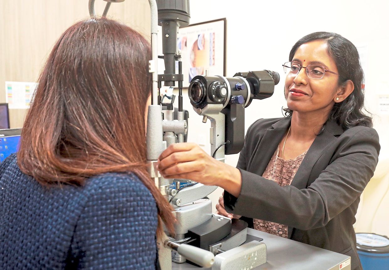 Dr Kala checks a patient's eye for abnormalities. She notes that ptosis, entropion and ectropion are unfortunately unpreventable. — SAMUEL ONG/The Star