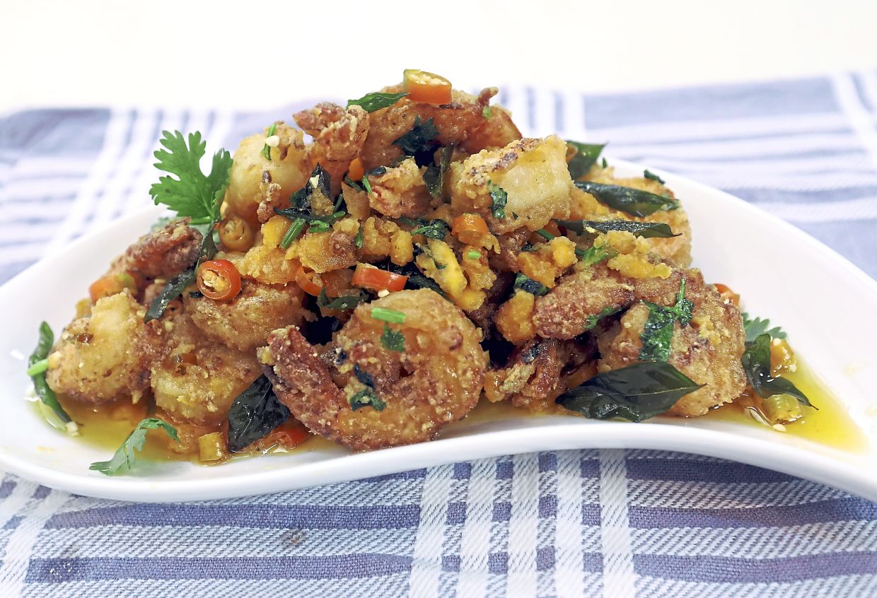These salted egg yolk prawns are crisp and buttery rich, making them the perfect indulgence. — Photos: AZLINA ABDULLAH/The Star While some restaurants prepare this dish with whole prawns, the heads and shells can be removed so that the salted egg does not end up in a pile of discarded shells.