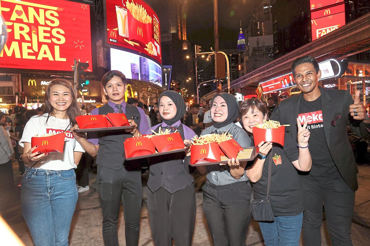 Chin (left) with staff and the special size fries that are available for a limited time. — Photos: ART CHEN/The Star