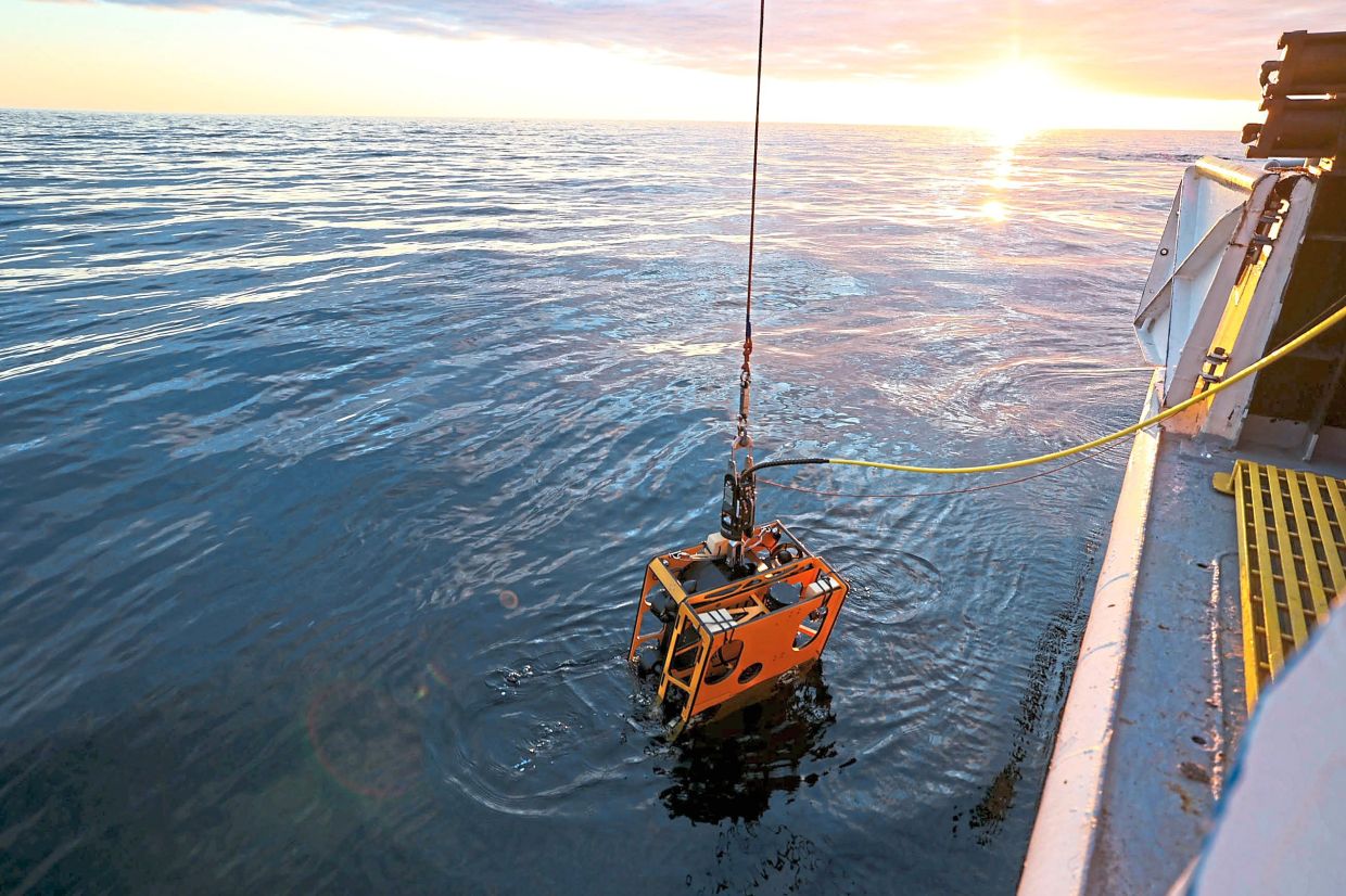 The underwater drone named Rhody being lowered into the lake for the first time in May. — The New York Times