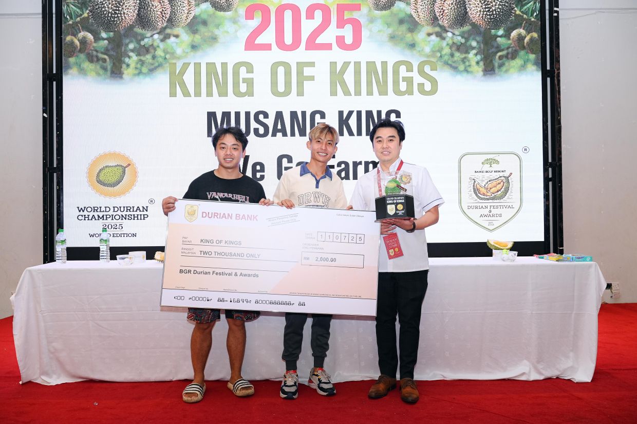 Head judge Eric Chan (right) presenting the “King of Kings” award to winners Lai Yuen Hong (left) and Ng Zi Cheng.