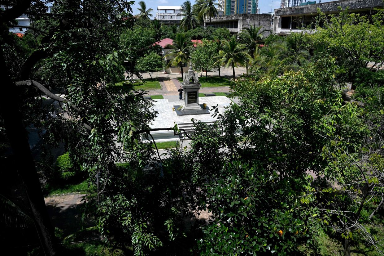 A tourist (centre) looks at a memorial for victims of the Khmer Rouge regime at the Tuol Sleng Genocide Museum in Phnom Penh on Saturday, July 12, 2025. Three notorious Cambodian torture and execution sites used by the Khmer Rouge regime to perpetrate genocide 50 years ago were inscribed on UNESCO's World Heritage List. Photo by TANG CHHIN Sothy / AFP)