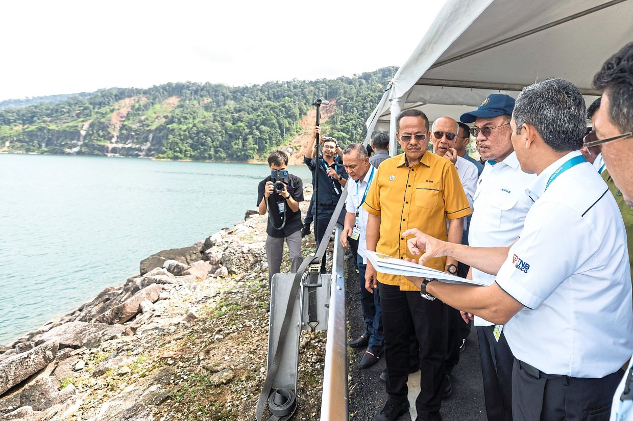 Sustainable solutions: Anwar (second from right) visiting the Hybrid Hydro Floating Solar project (below) in Kenyir, Terengganu. — Bernama