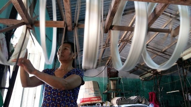 A weaver spins silk yarns at a workshop in Ma Chau silk village.