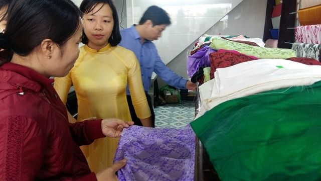 Tran Thi Yen (second left) introduces silk products at a showroom of Ma Chau Silk. - Photo: VNS