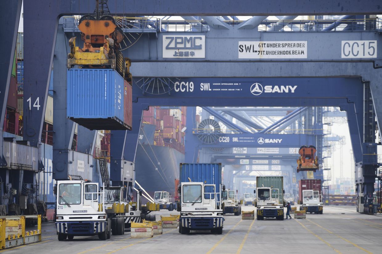 Cranes unload shipping containers from trucks at Jakarta International Container Terminal (JICT) at Tanjung Priok Port in Jakarta, Indonesia. -- AP Photo/Tatan Syuflana)