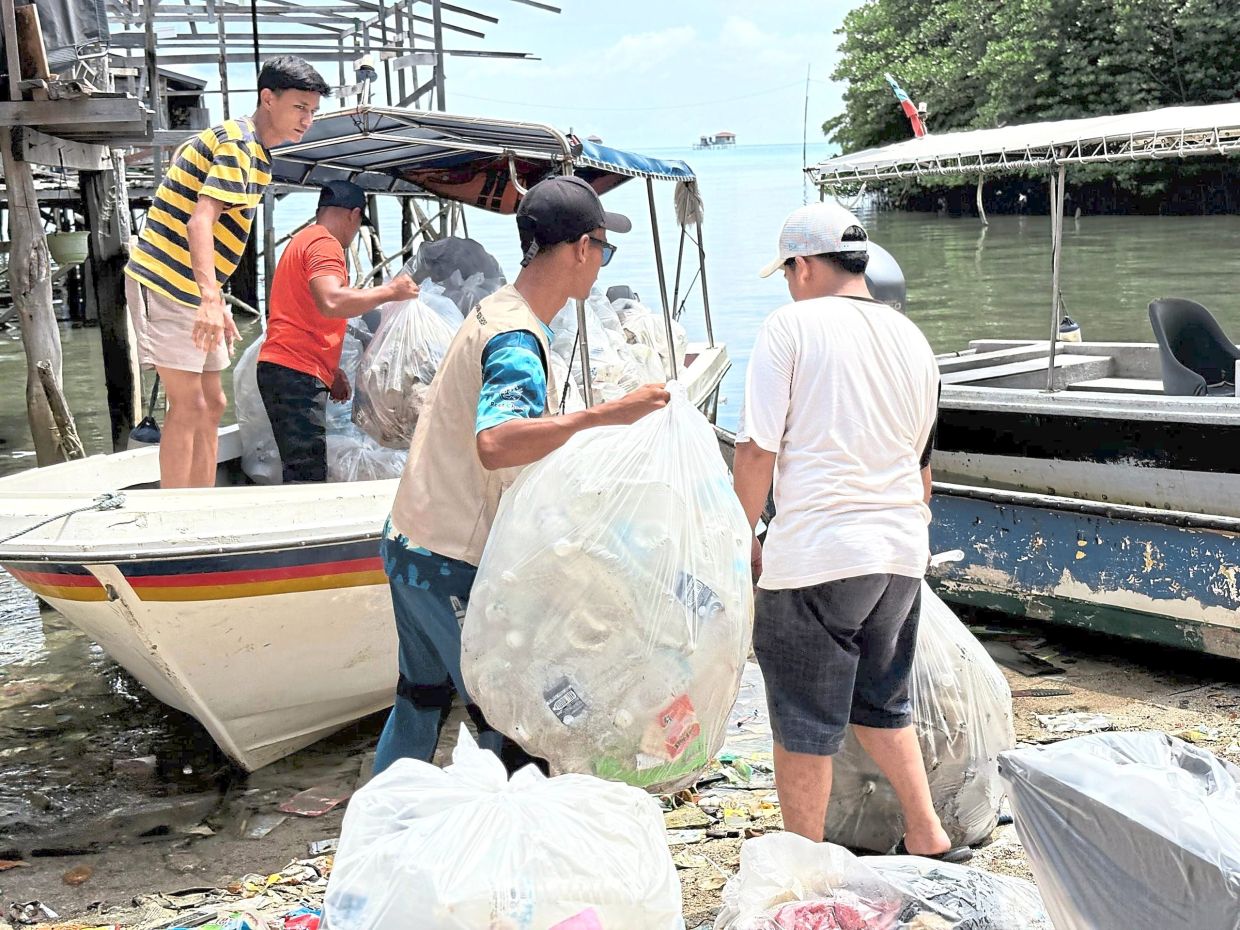 Residents loading sorted waste onto boats for transfer to the mainland.