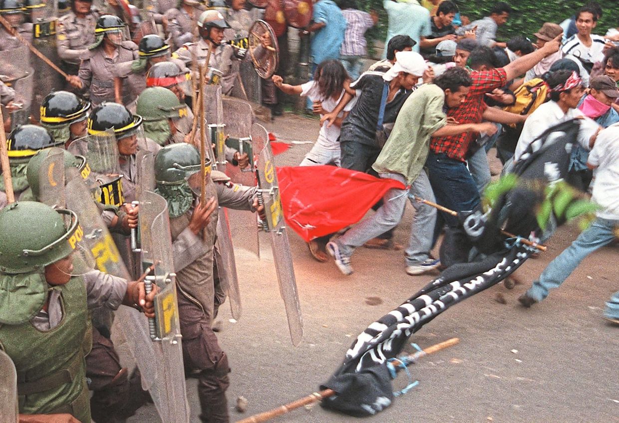 Rriot police charging a crowd of National University students attempting to leave their campus on May 6, 1998.— AFP