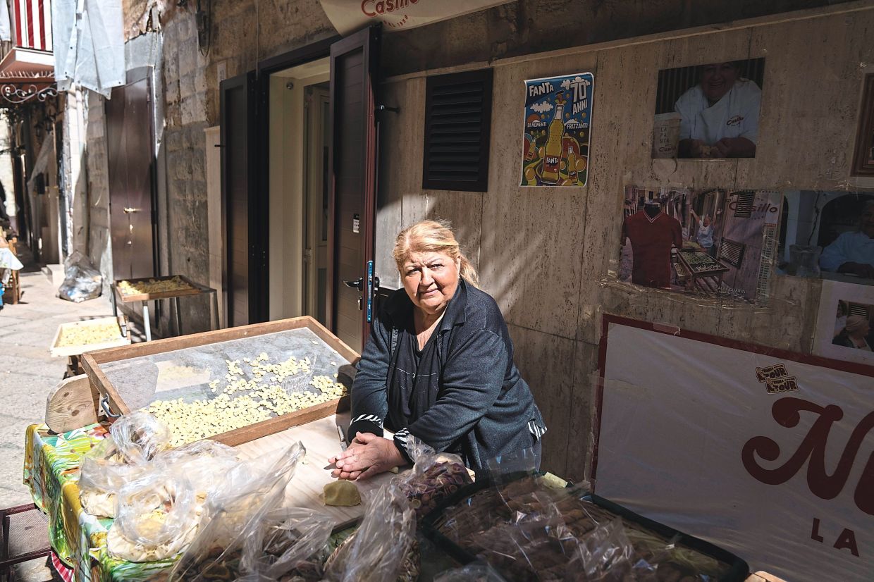 Nunzia Capito making home-made ear-shaped orecchiette pasta which she sells along Arco Basso in Bari. — Gianni Cipriano/The New York Times