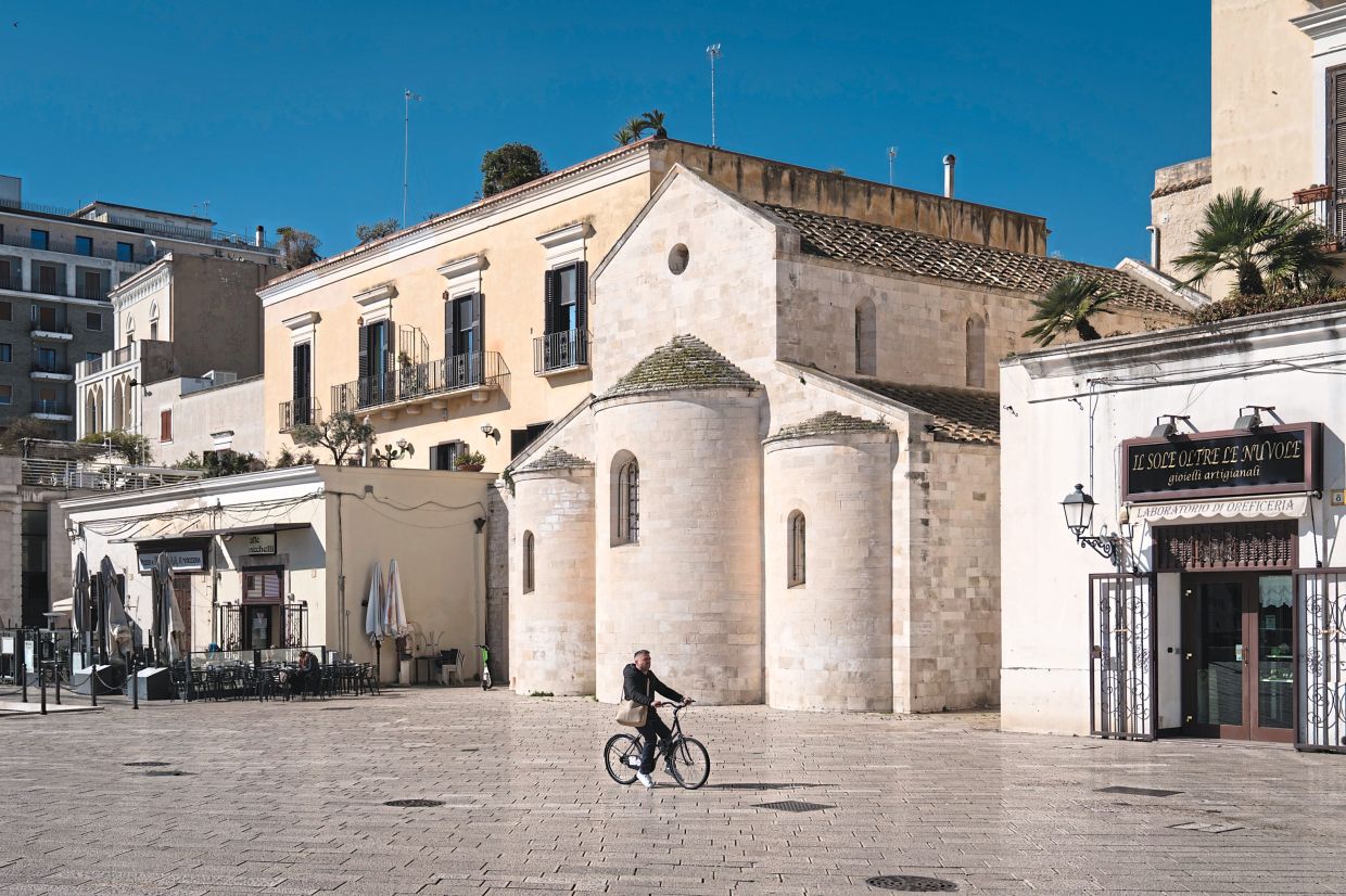A man riding his bicycle through Piazza Mercantile in Bari. Foreigners – and residents – long avoided Bari’s old town, which had been plagued by mob crime and now, with direct flights from the United States starting, residents are excited but wary. — Gianni Cipriano/The New York Times