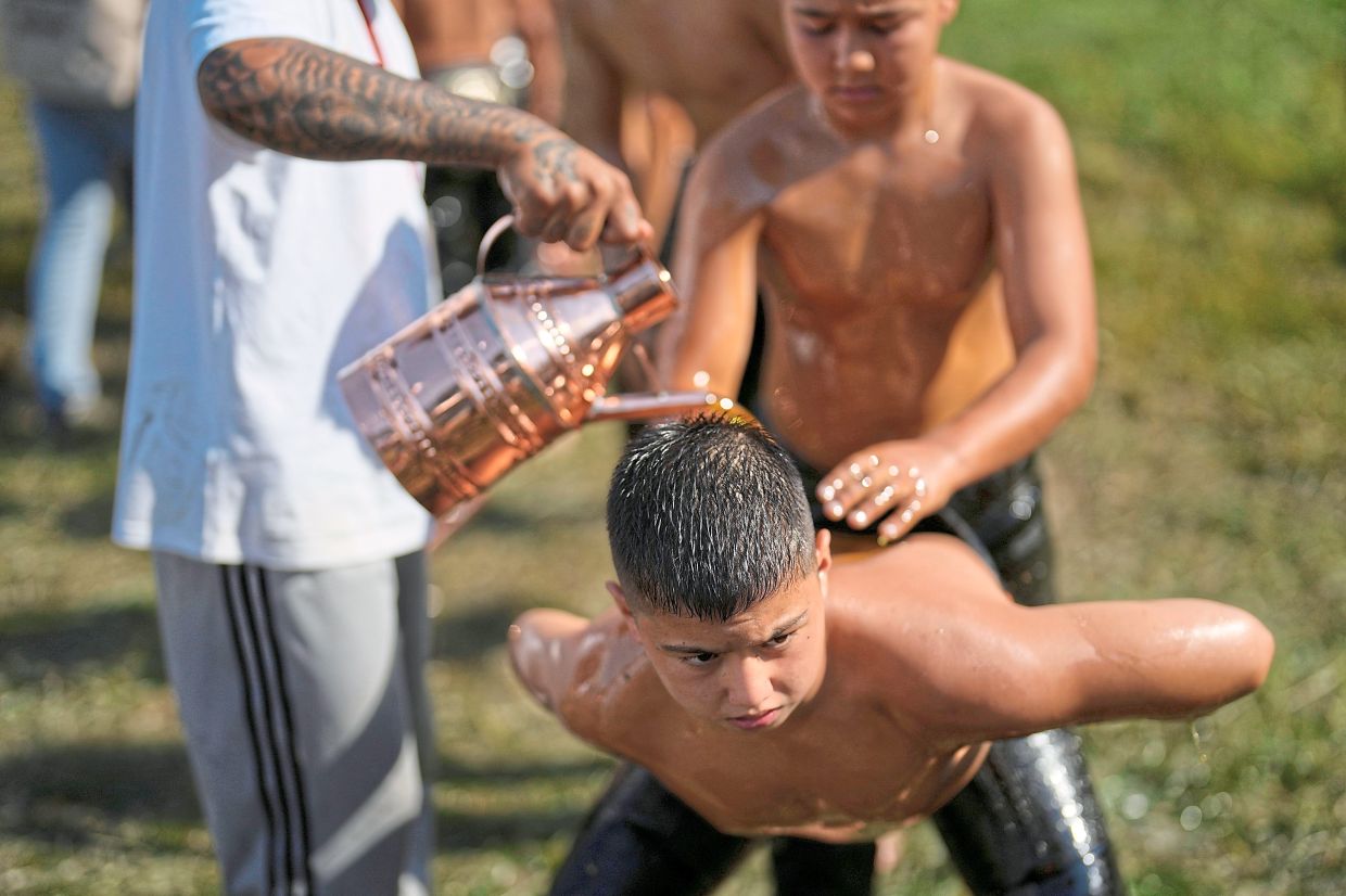 A young wrestler getting doused in oil during the festival.