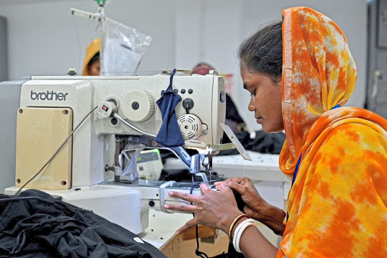 Eye for detail: Garment worker Raimoni Bala, 32, working inside the sewing section of a garment factory in Ashulia, on the outskirts of Dhaka, Bangladesh. — Reuters