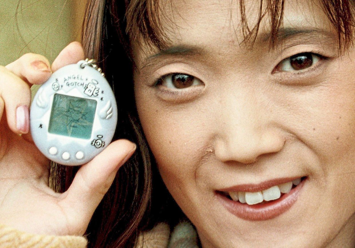 Aki Maita, Japanese developer of the Tamagotchi digital pet, shows on Dec 15, 1997, the new product AngelGotchi in Hamburg, Germany. — OLIVER FANTITSCH/AP