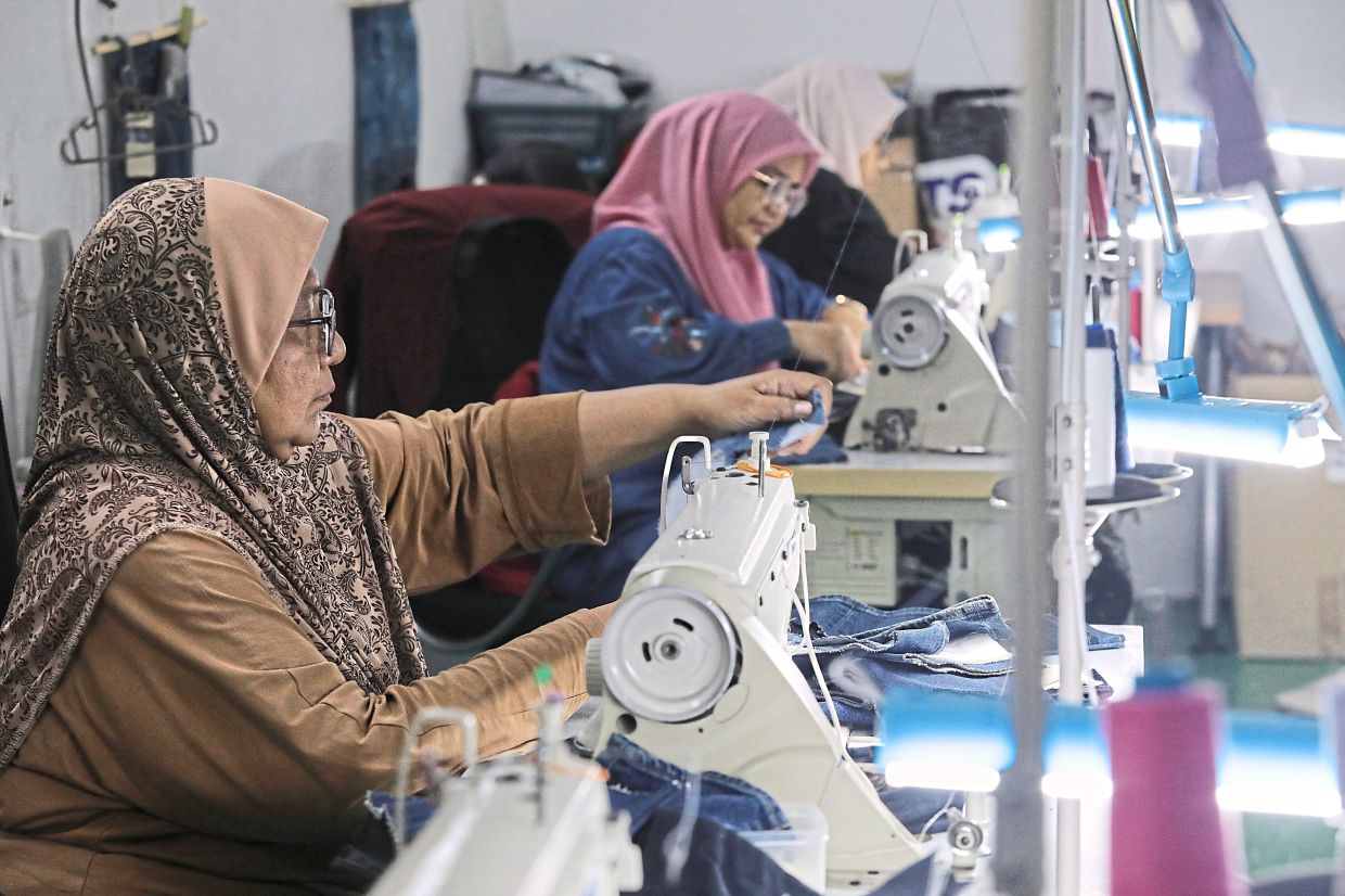 Suri Lifestyle employees sewing the denim fabric into tote bags. — Photos: YAP CHEE HONG/The Star
