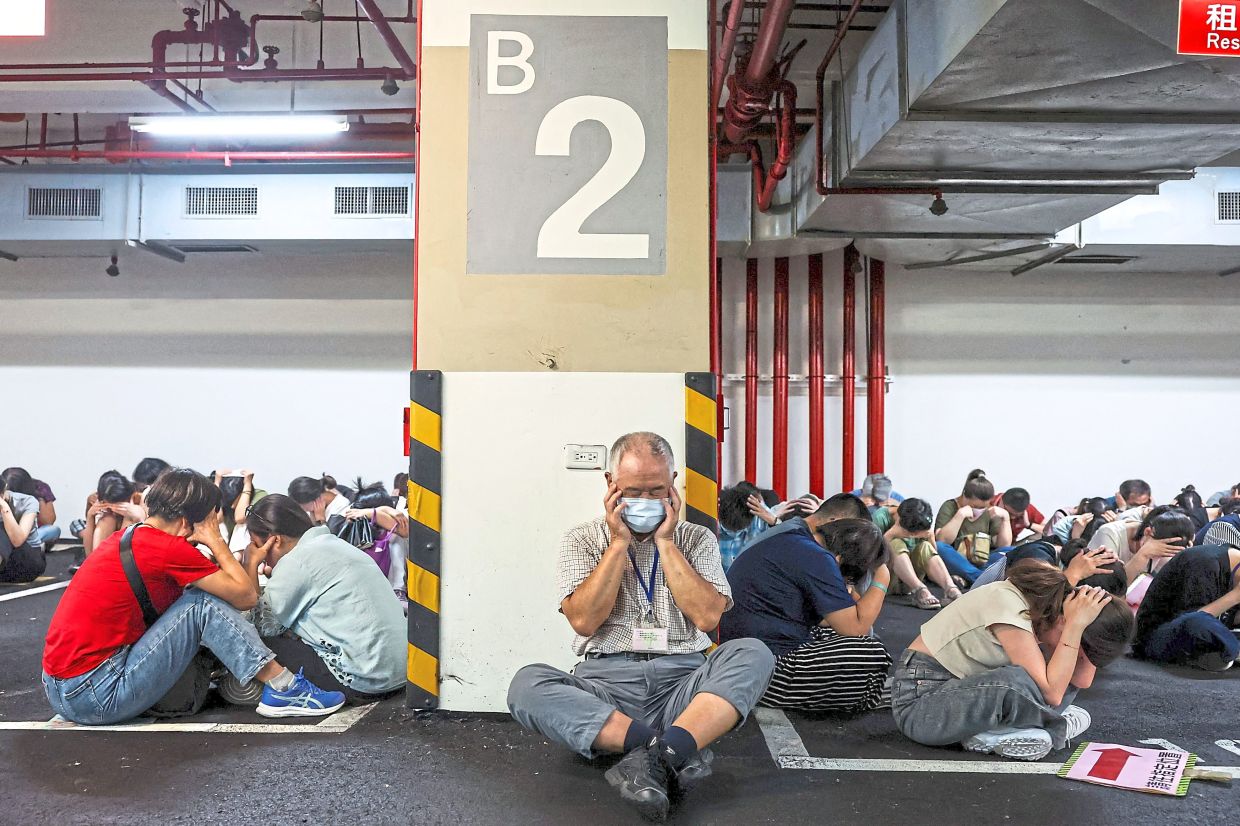 Duck and cover: People taking shelter during an air raid drill coinciding with military exercises in Taipei. — AFP