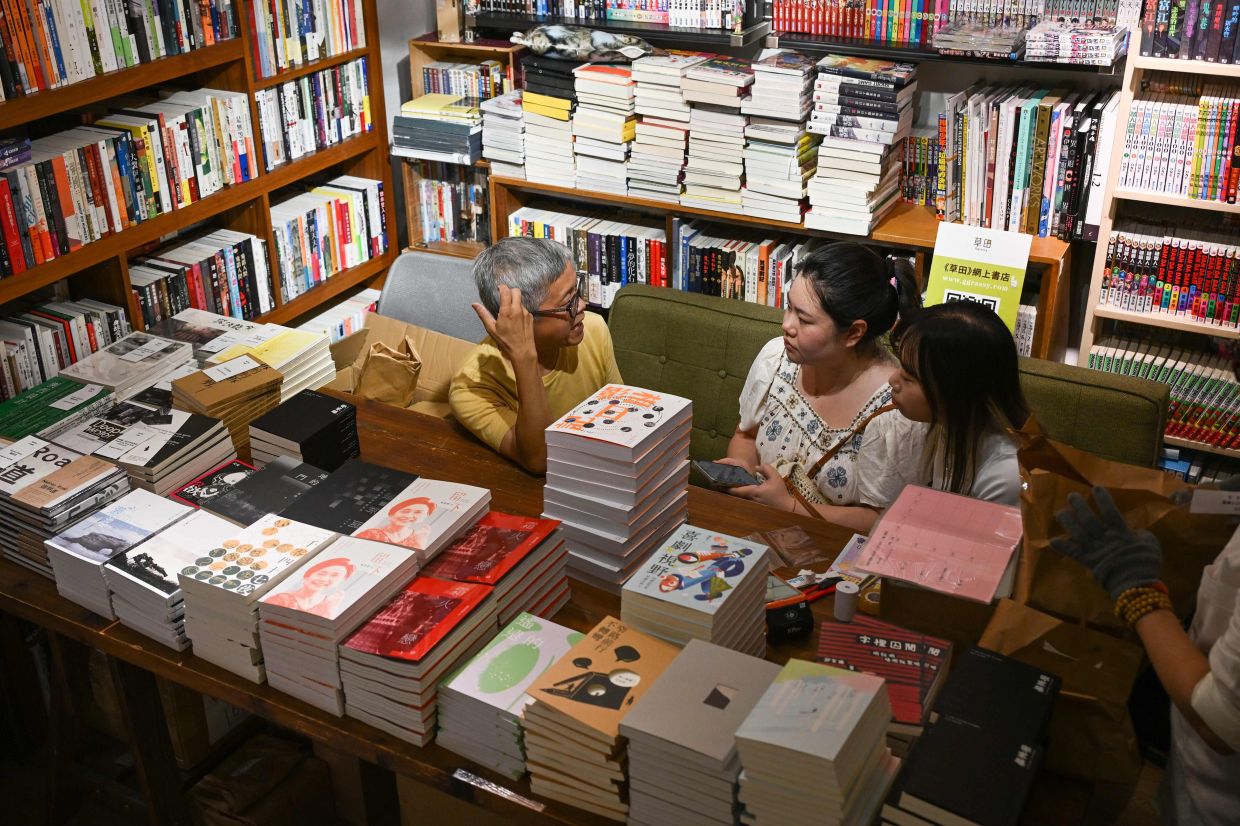 Independent publisher Leslie Ng (centre) speaks to journalists at Hunter Bookstore, where the unofficial Hong Kong Independent Book Fair is being held. Photo: AFP