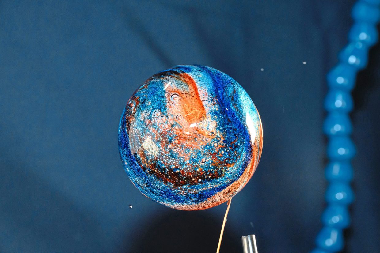 A sphere of water with food colouring injected into it abroad the ISS. The different conditions in space can have effects on human bodies that may be utilised to help develop treatments for various illnesses.