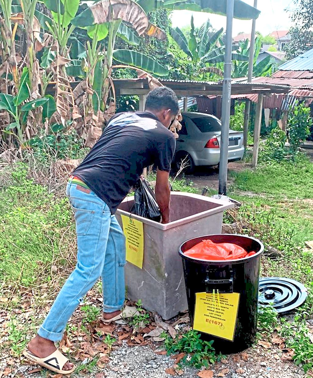 Tags are fixed on rubbish bins of residents in Kampung Sungai Ramal Dalam who have paid for waste collection, to make it easier for contractors to identify the ones that should be cleared.