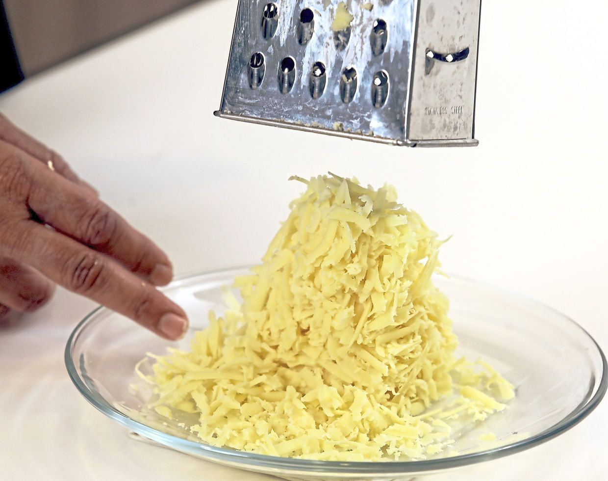 Use a box grater to shred the aged hard cheddar.