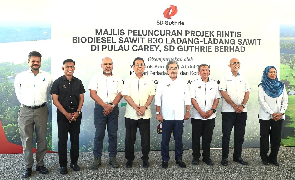 One for the album: Johari (fourth from right) taking a group photo with Nik Norzrul (fourth from left) and SD Guthrie’s group managing director Datuk Mohamad Helmy Othman Basha (third from left) after the launch of SD Guthrie’s B30 biodiesel pilot project (below) in Carey Island. — KK SHAM/The Star