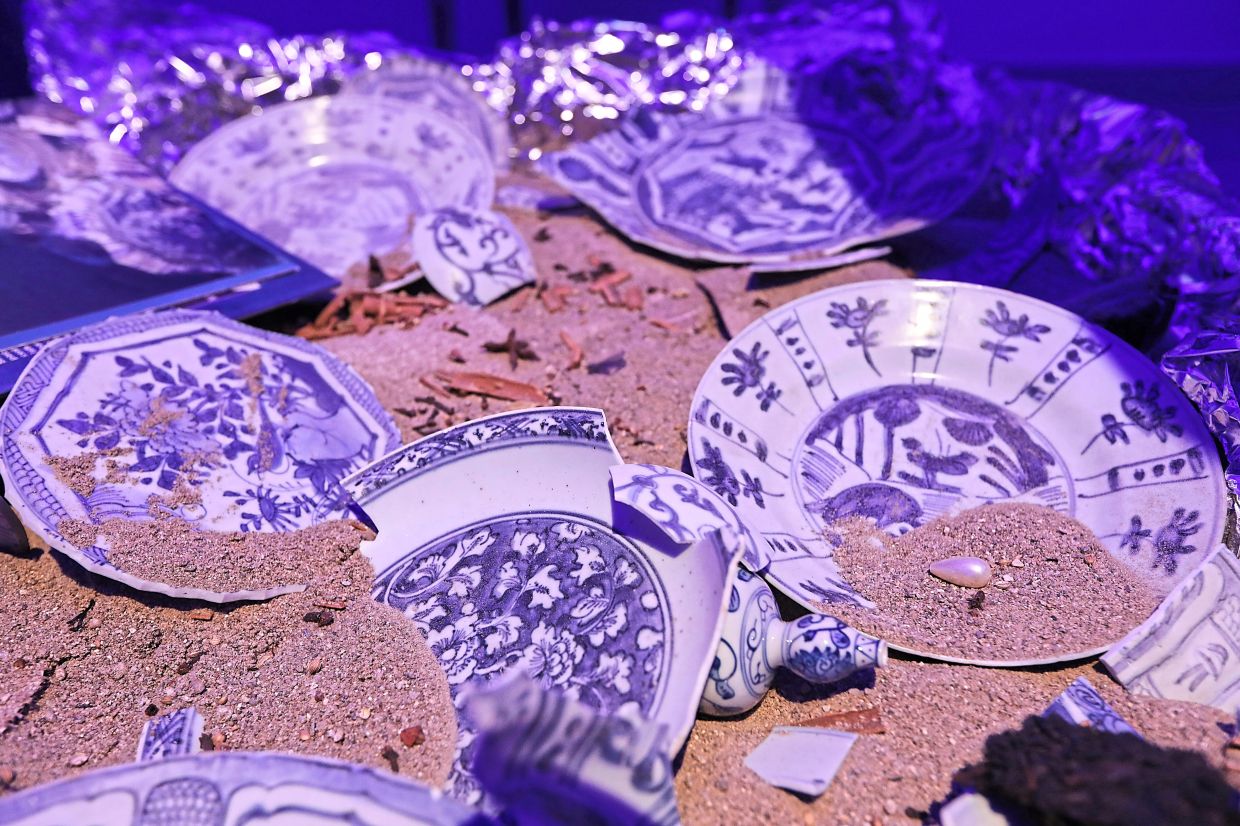 Visitors are free to pick up and examine the loose porcelain pieces that fill the sandbox set in the middle of the exhibition. Photo: The Star/Yap Chee Hong 