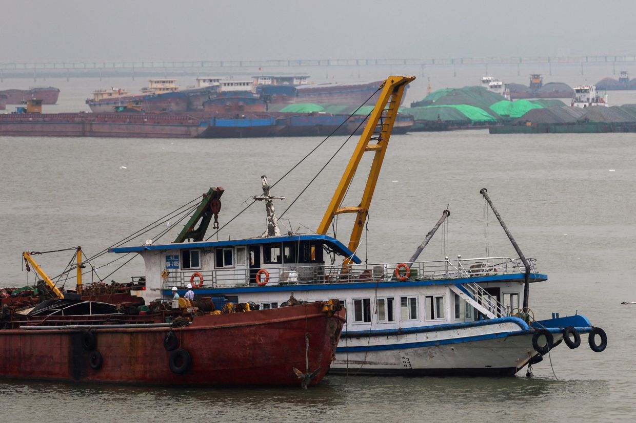 A tourist boat (in white) that capsized in an accident which killed dozens and left several people still missing, is towed back to the port in Halong Bay, Quang Ninh province, Vietnam, July 20, 2025. - Photo: Reuters